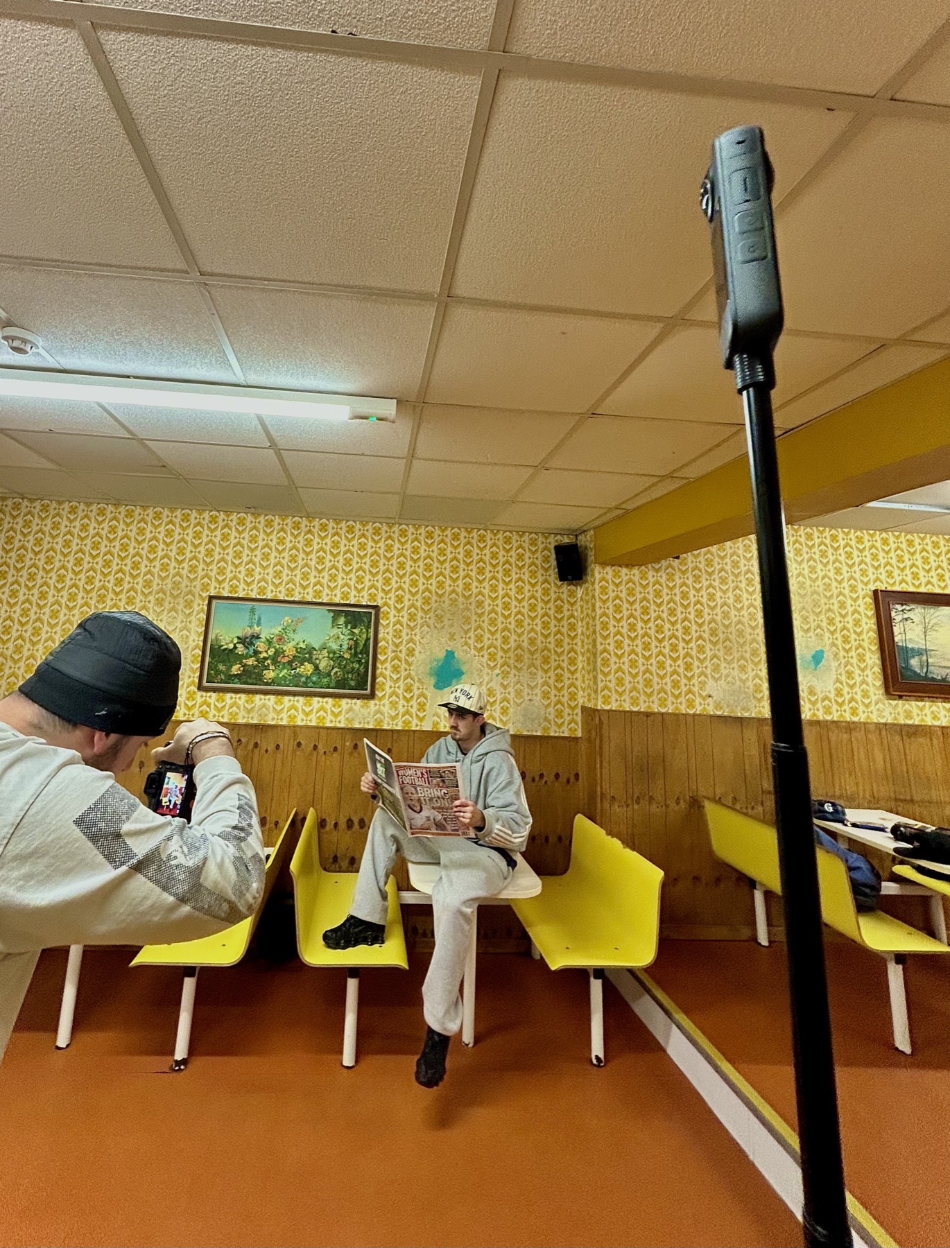 Benji photographing a model in a yellow cafe interior