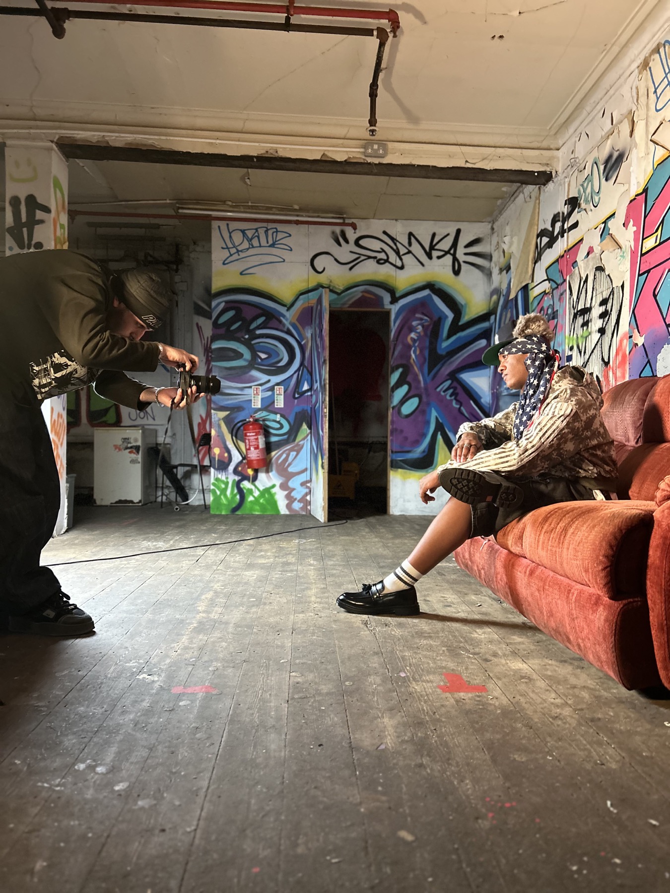 Benji photographing a model inside a graffiti covered location