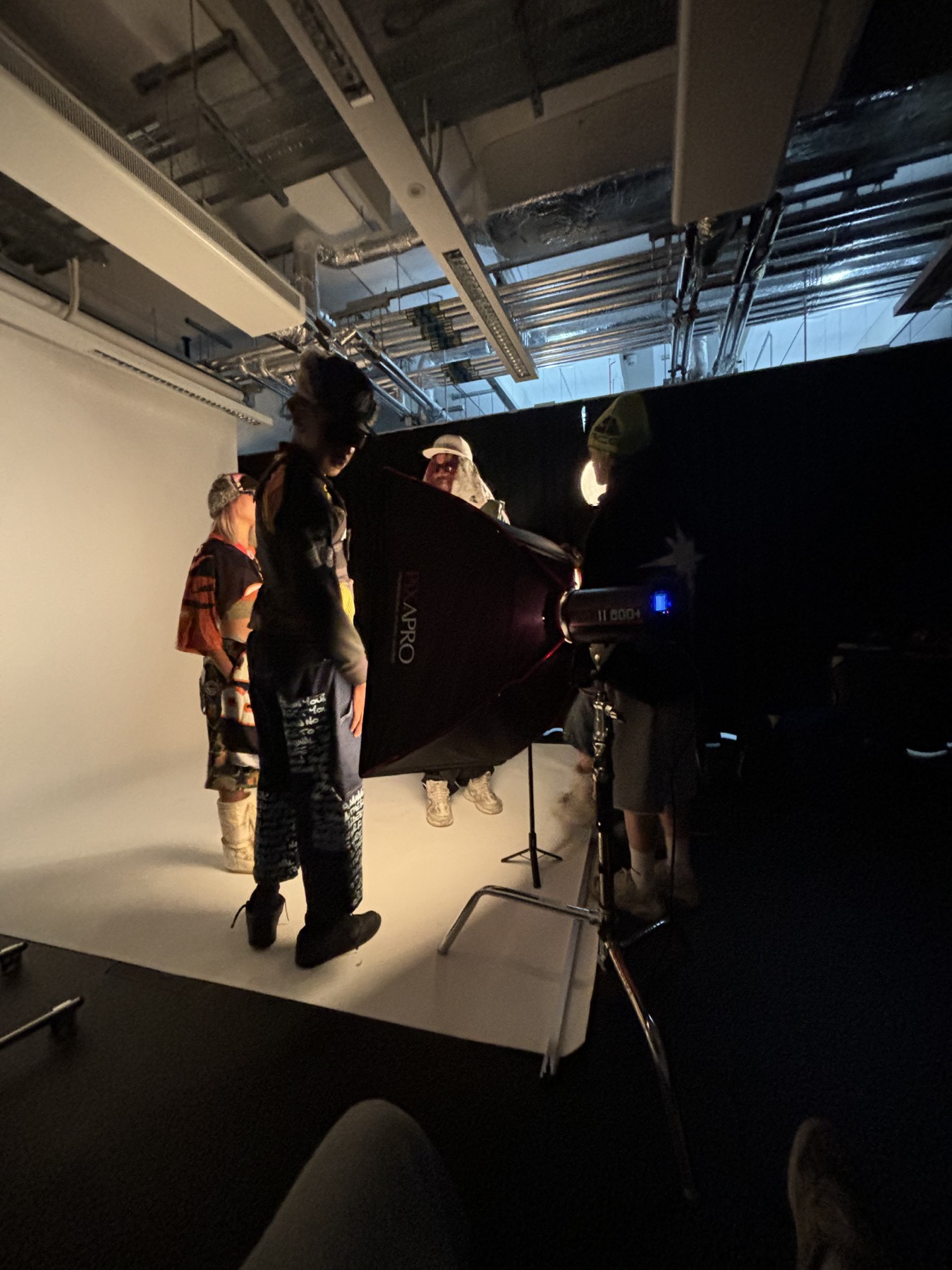 Crew shaping studio lighting around a fashion set