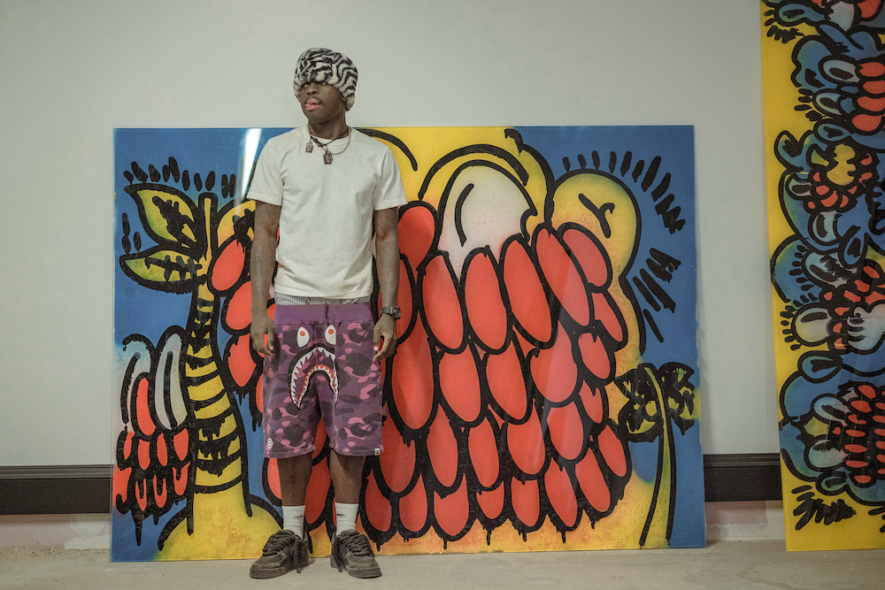 Slawn standing in front of his paintings